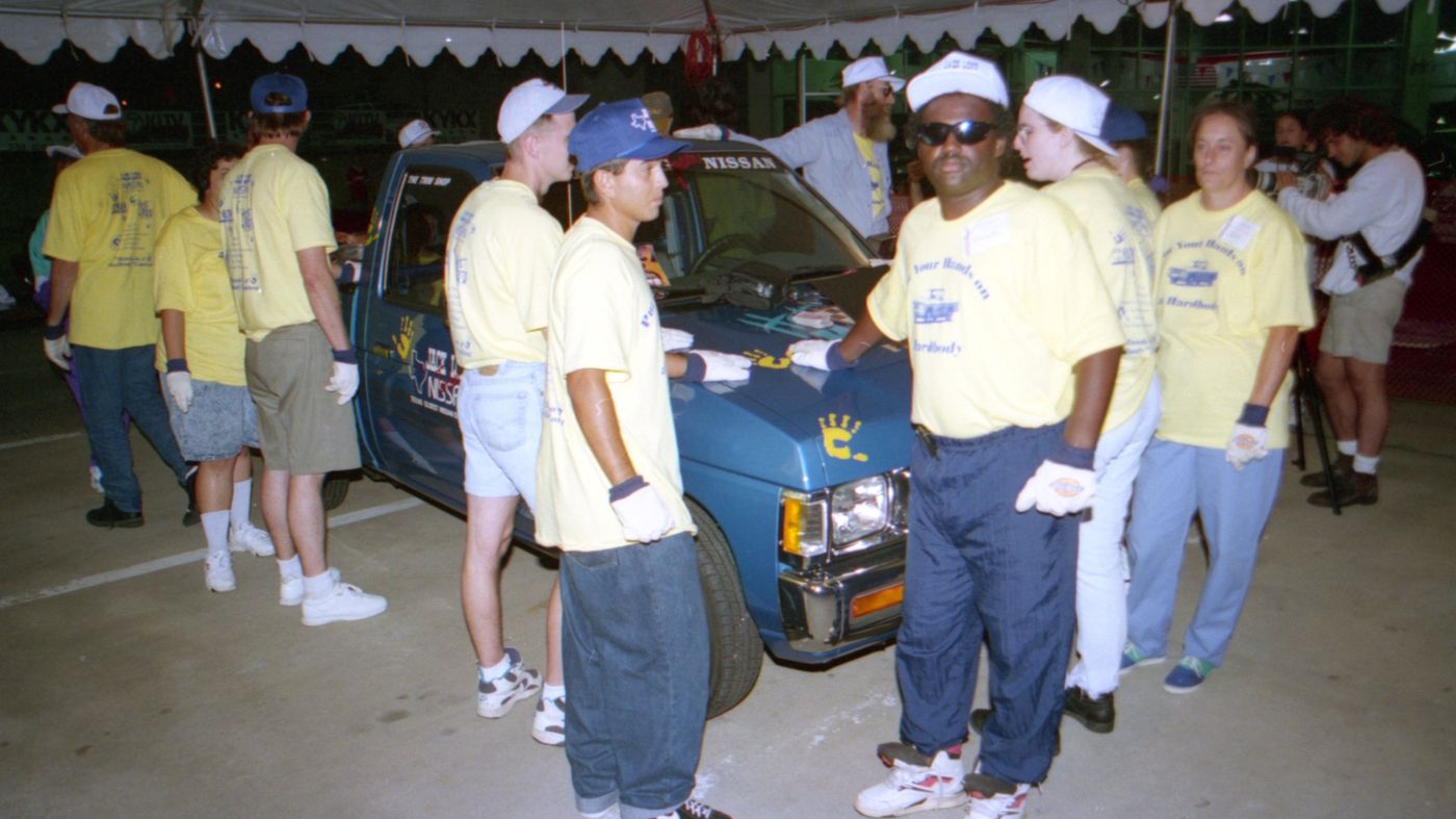 A contestant in sunglasses at the front of the truck at night